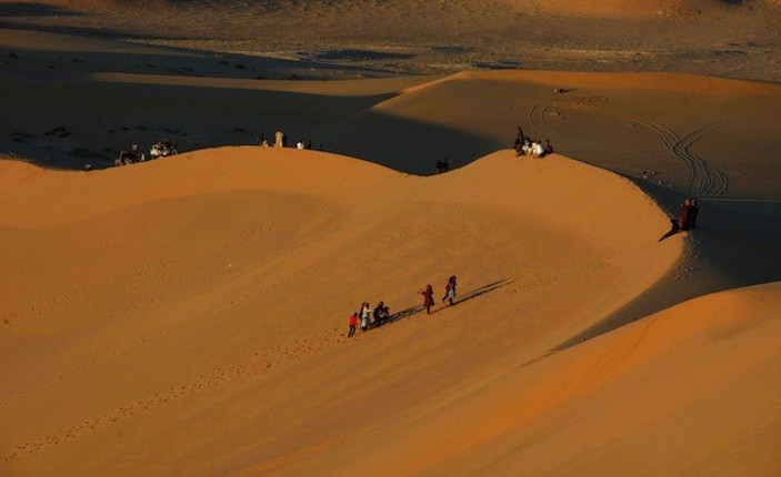 Migranti attraversando il deserto libico